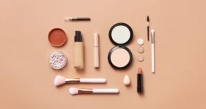 This image showcases a variety of cosmetic products and makeup accessories arranged on a pastel-colored background. The background create a soft, feminine aesthetic..